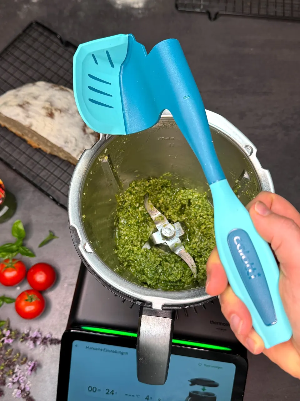 Randvoller Thermomix® TM7 Mixtopf mit Pesto, darüber der Calotti® Drehkellenspatel SILIKON+