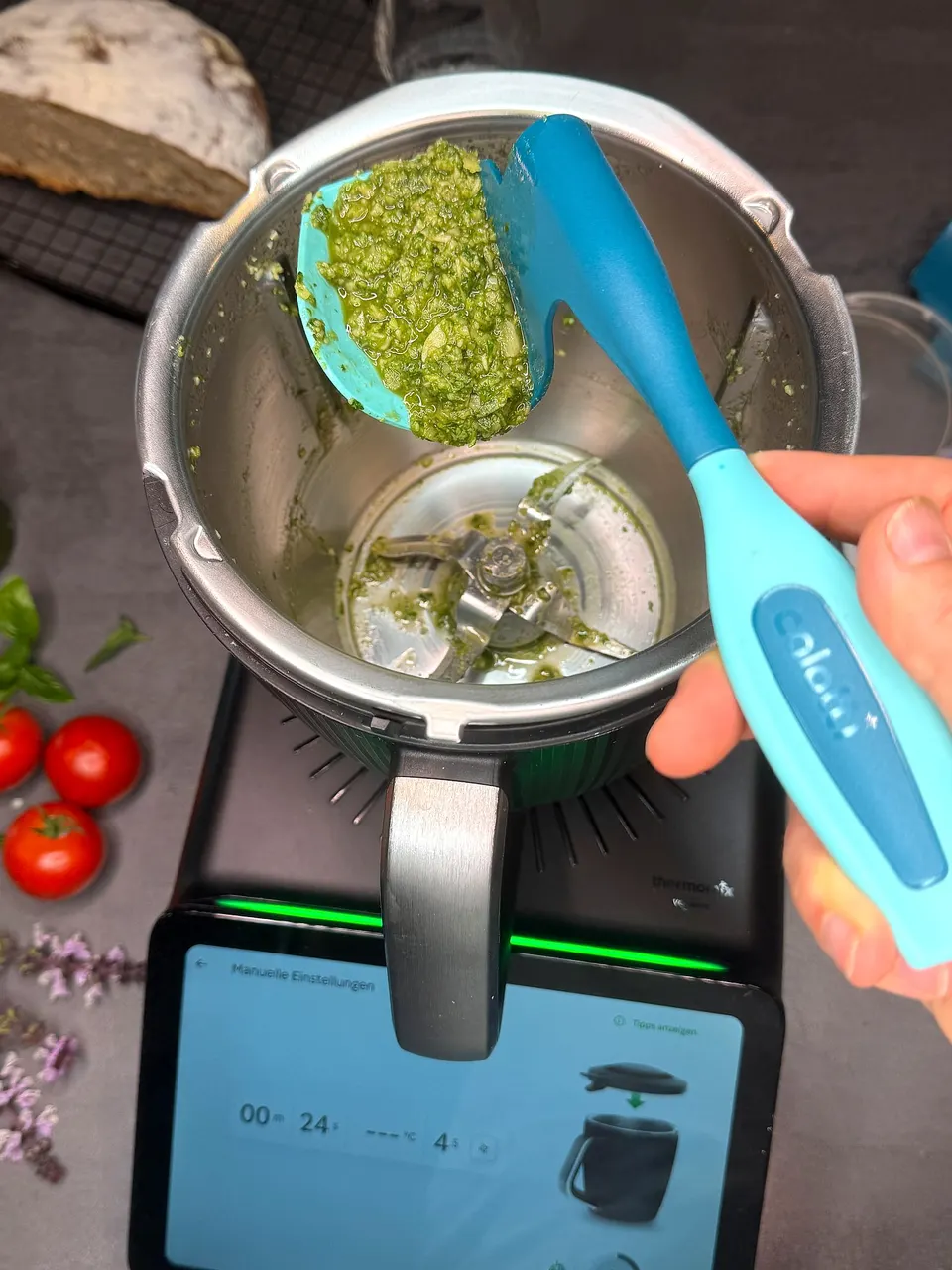 Calotti® Drehkellenspatel SILIKON+ voll Pesto über dem Thermomix® TM7 Mixtopf, darunter das Display
